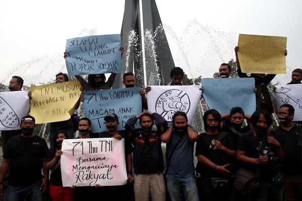 Sejumlah wartawan dari Pewarta Foto Indonesia (PFI) Medan bersama organisasi jurnalis lainnya menggelar aksi unjuk rasa memprotes penganiayaan jurnalis oleh oknum TNI, di Bundaran air Mancur Mandiri Jalan Sudirman Medan, Rabu, (5/10). Aksi itu merupakan bentuk protes atas tindak kekerasan yang dilakukan oknum TNI terhadap jurnalis di Medan dan Madiun. PotretBisnis/A.Susno