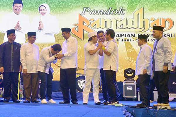 Gubernur Sumut Tengku Erry Nuradi bersalaman dengan vocalis Wali, Farhan ZM (Faank) saat tampil memeriahkan pembukaan PRSUF perdana di lokasi Pekan Raya Sumatera Utara (PRSU) Tapian Daya, Jl Gatot Subroto Medan, Jumat (10/6/) malam. PotretBisnis/Andi Rambe-Rel